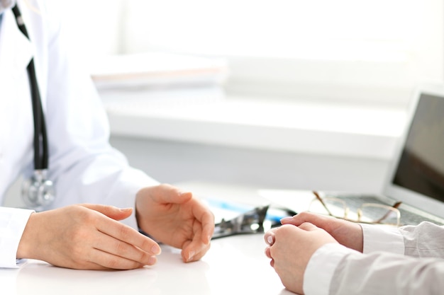 Doctor and patient sitting at the desk. Medicine and health care concept