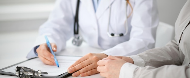 Doctor and patient sitting at the desk. Medicine and health care concept