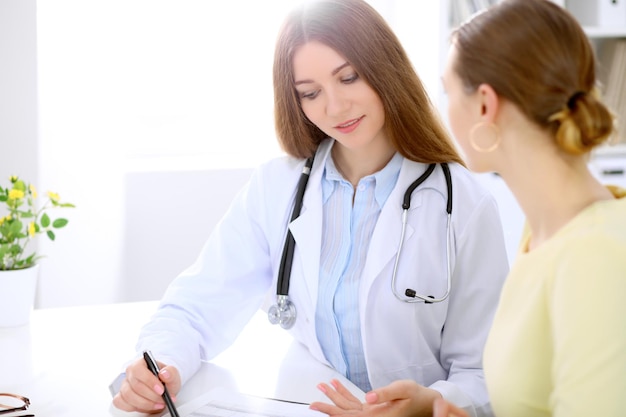 Doctor and patient sitting at the desk near window