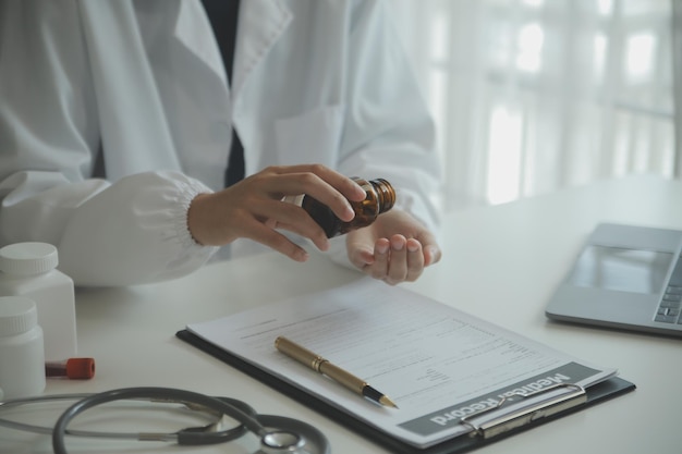 Doctor and patient sitting and talking at medical examination at hospital office closeup Therapist filling up medication history records Medicine and healthcare concept