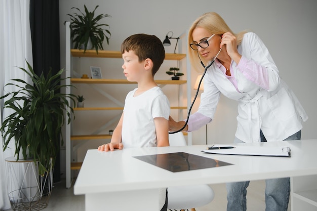 小児科医が子供を診察する女性医師が聴診器を子供の胸に当て、小さな男の子の心拍と肺に耳を傾けるヘルスケアと小児科の診察の概念