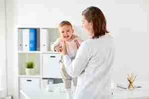 Photo doctor or pediatrician holding baby at clinic