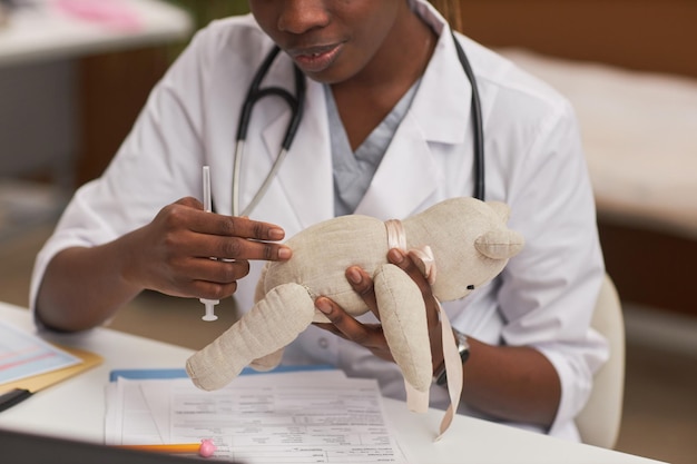 Doctor performing injection using toy