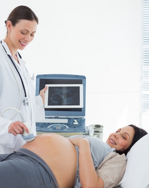 Doctor performing ultrasound on expectant woman