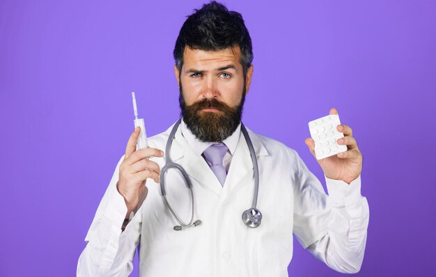 Врач или фармацевт с таблетками и шприцем лечит заболевания современными методами медицинского препарата