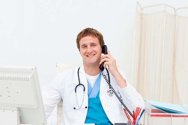 A doctor on phone smiling at the camera