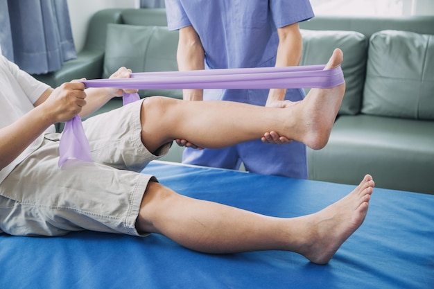 Doctor or physiotherapist working examining treating injured arm of athlete male patient stretching and exercise doing the rehabilitation therapy pain in clinic