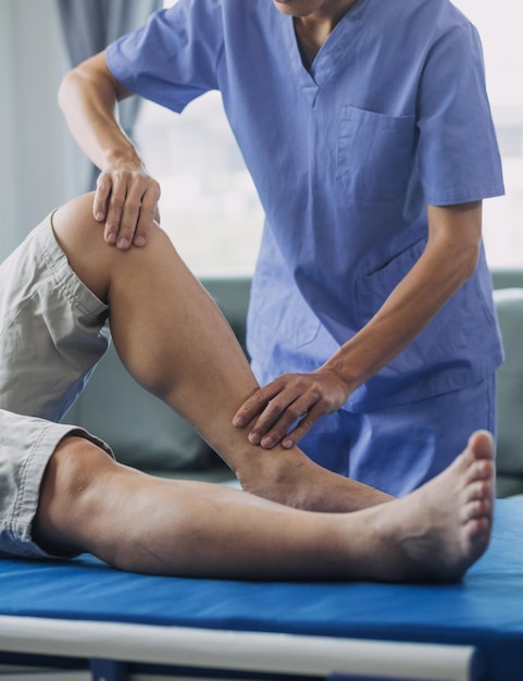 doctor or physiotherapist working examining treating injured arm of athlete male patient stretching and exercise doing the rehabilitation therapy pain in clinic