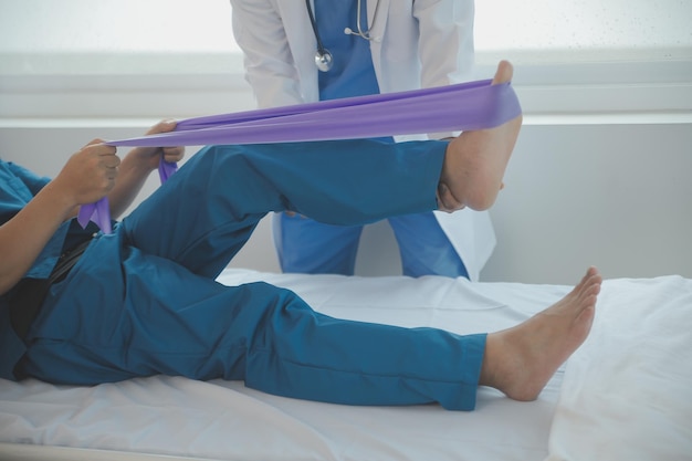 Foto medico o fisioterapista che lavora esaminando il trattamento del braccio ferito dell'atleta paziente maschio stretching ed esercizio fisico facendo il dolore della terapia riabilitativa in clinica