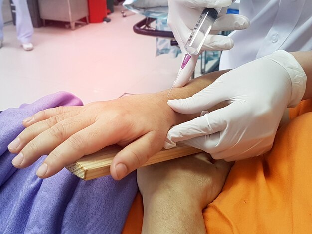 doctor pierces wrist with a syringe for injectionbroken wrist from accident