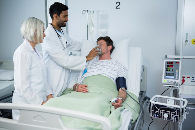 Doctor placing an oxygen mask on the face of a patient