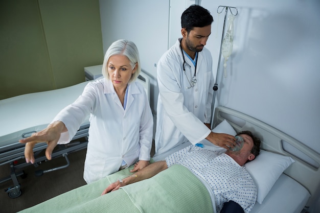 Photo doctor placing an oxygen mask on the face of a patient