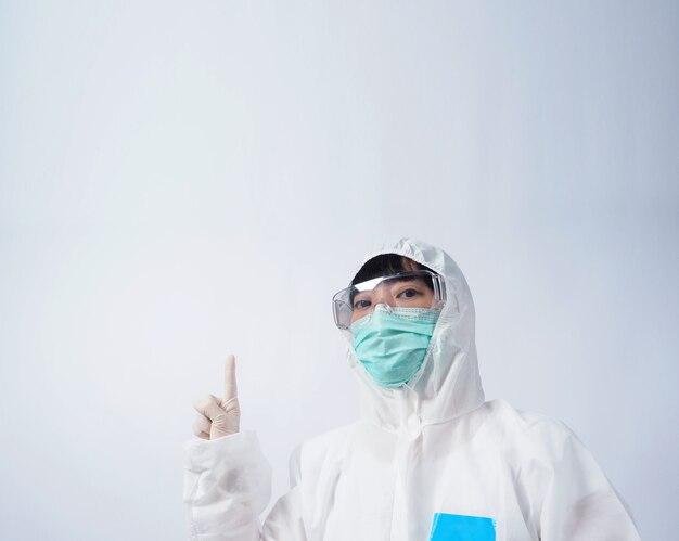 Doctor in PPE suit or Personal Protection Equipment point out to copy space and wearing white color