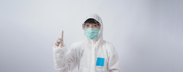 Doctor in PPE suit wearing white medical rubber gloves and clear goggles and green N95 face mask to protect pandemic Coronavirus gesture make hand sign Represent victory win over virus Isolated