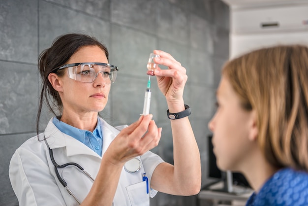 Photo doctor preparing a vaccine to inject into a patient