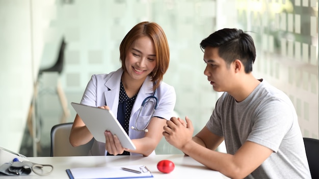 Doctor presenting a patient some information on a digital tablet