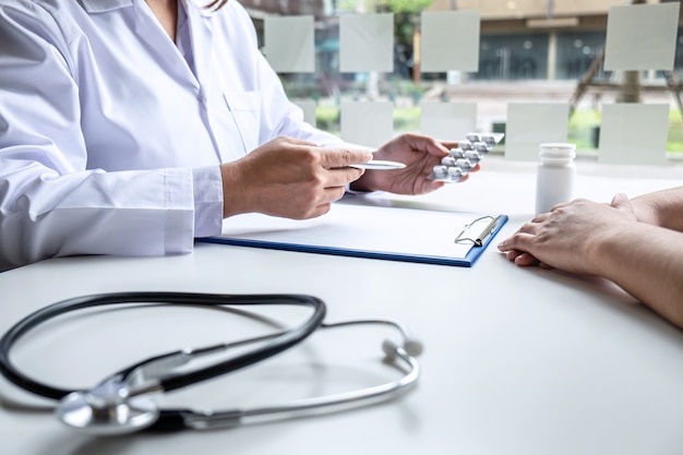 Doctor presenting with patient and checking results on report and prescription about the problem