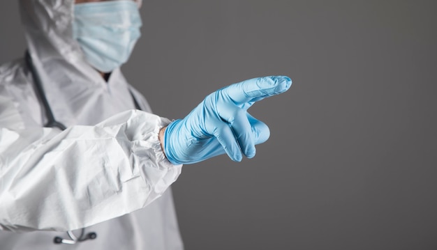 Doctor presses a finger on a virtual screen on a gray scene