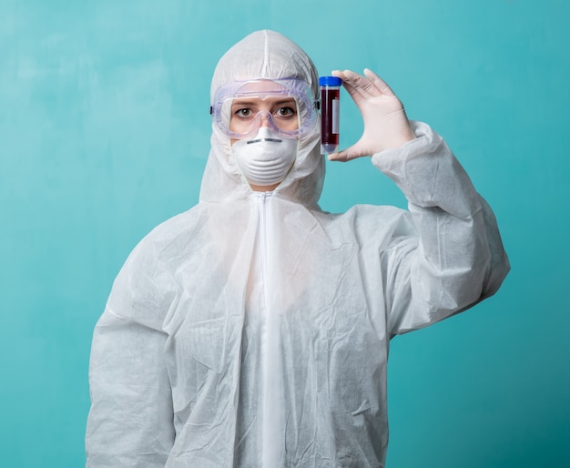 Doctor in protection clothes holds COVID-19 vaccine