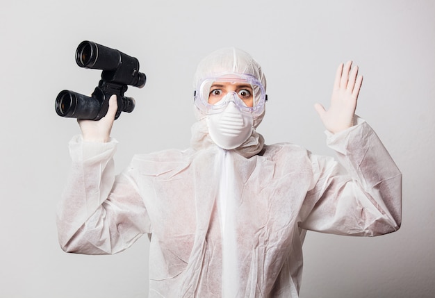 Photo doctor in protection suit and glasses, mask with binoculars