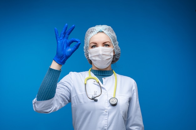 Doctor in protection uniform showing OK hand sign.