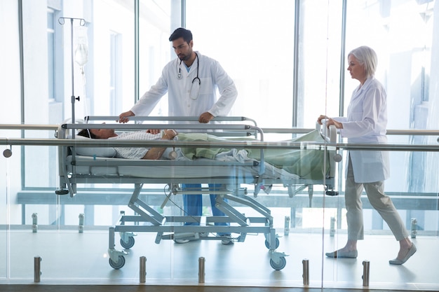 Photo doctor pushing emergency stretcher bed in corridor