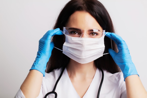 Doctor puts on protective surgical mask for protection