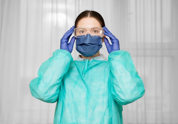 Doctor puts on safety glasses, coronavirus protection, security measures, preparation for the work of a doctor