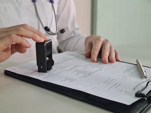 Doctor puts a stamp on medical documents closeup