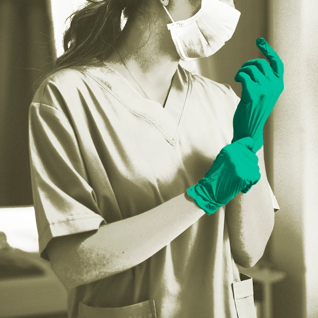 Doctor putting on a glove to prevent coronavirus contamination