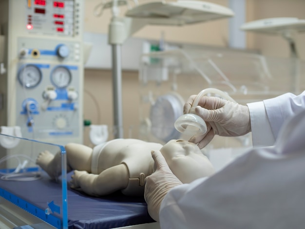 A doctor putting an oxygen mask on a newborn infant