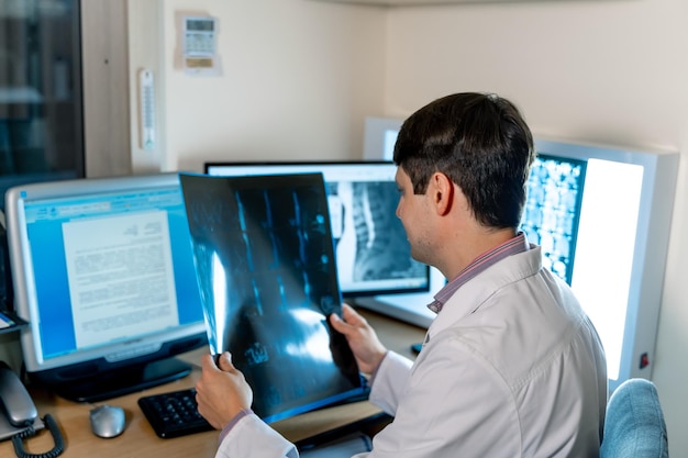 Doctor radiologist sitting near computer Diagnosis at monitor View from the back Neurosurgery concept