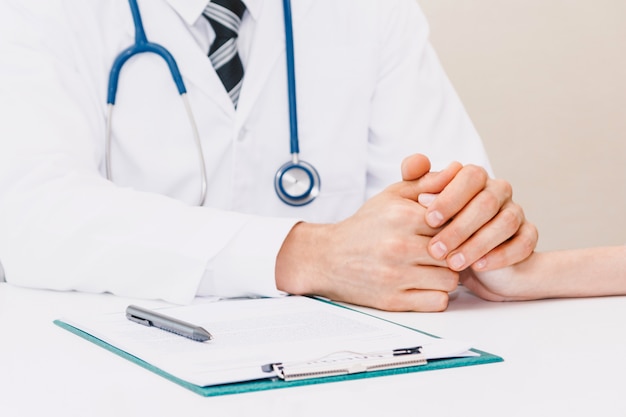 Doctor reassuring her female patient with care on doctors table in hospital.healthcare and medicine