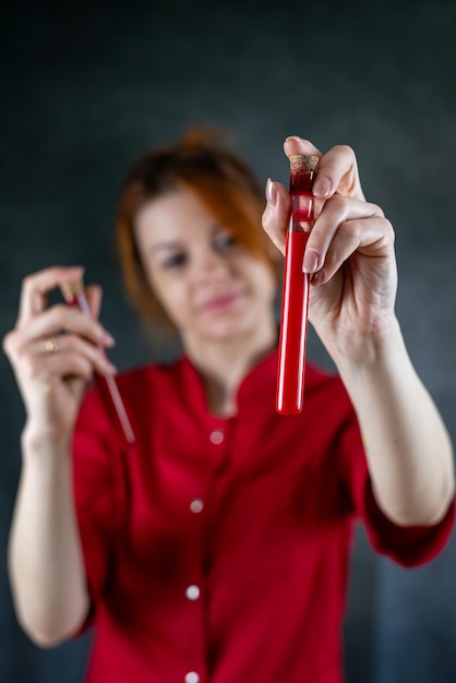 Doctor in red uniform examining blood at test tube protection against pandemic