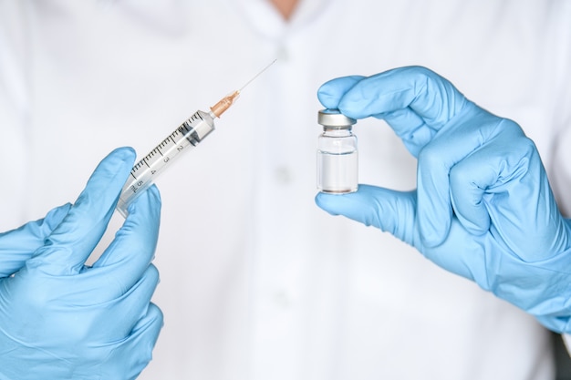 Doctor, researcher or scientist hand in blue glove holding flu