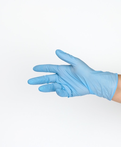 Doctor's hand in a blue medical glove holds an object on a white background. Copy space, hold any object