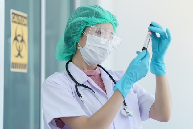 Doctor's hand holding a test tube with contaminated blood sample inside