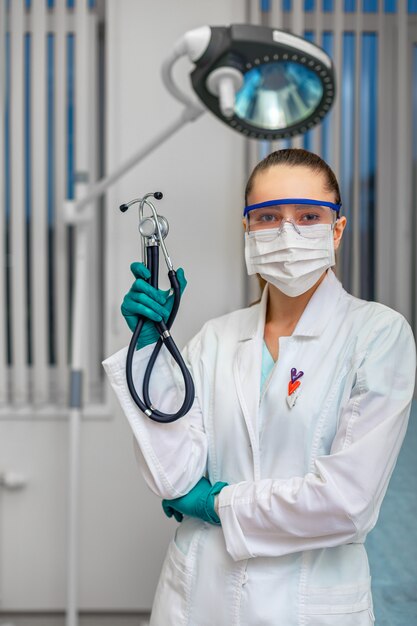 Doctor's hand in white coat holding a phonendoscope