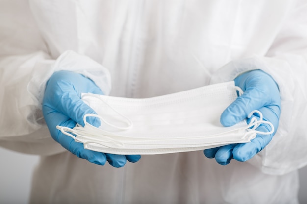 Doctor's hand with some medical face mask for protection against infection