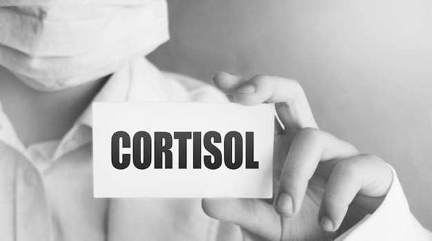 Cortisol 단어 면역 시스템 의료 의료 개념이 있는 흰색 카드가 있는 의사의 손