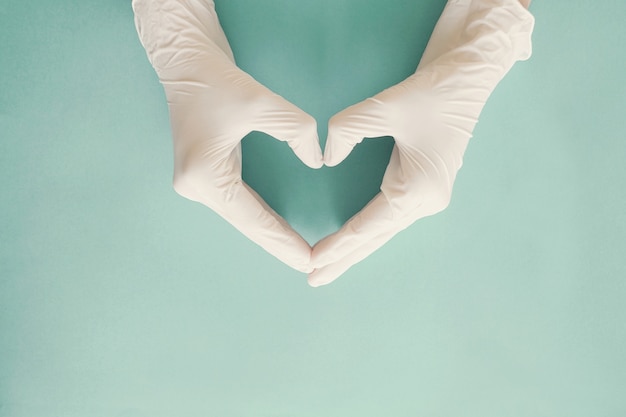 Doctor's hands with medical gloves making heart shape