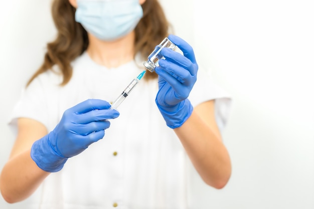 Doctor's hands with syringe and ampoule