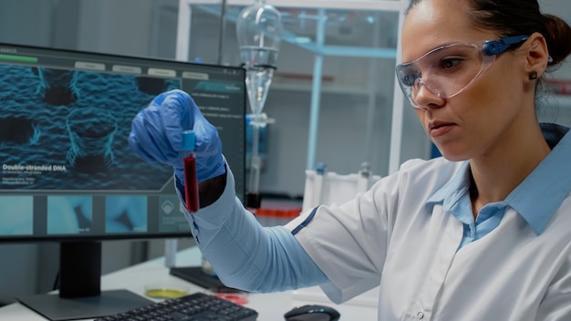 Photo doctor in science laboratory analyzing tray of vacutainers