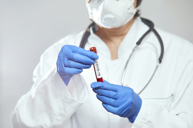 코로나 바이러스 분석을위한 혈액 테스트 튜브를 들고 의사 과학자