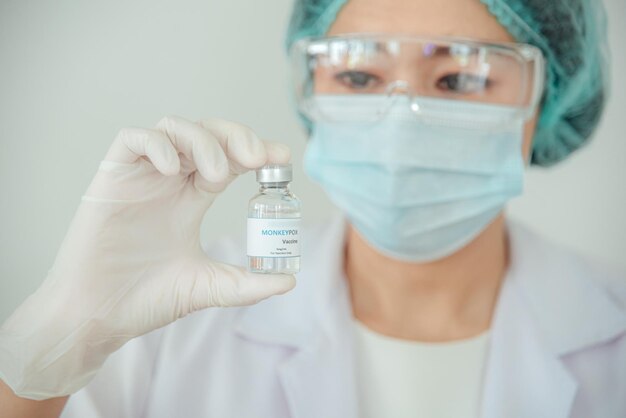 의사 또는 과학자가 원숭이 수두 또는 클레이드에 대한 백신 병을 들고 있다