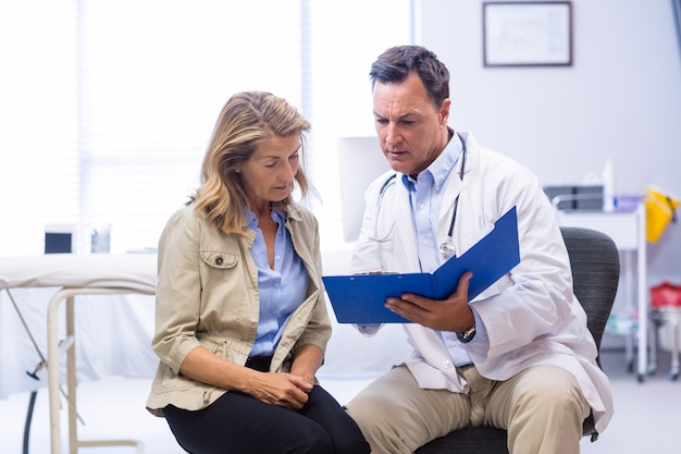 Doctor and senior woman discussing on file