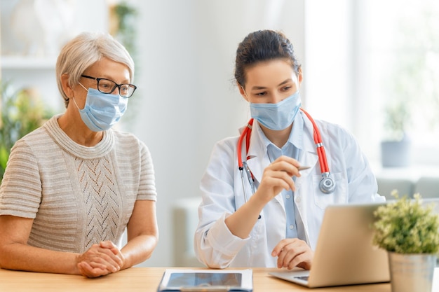 Doctor and senior woman wearing facemasks