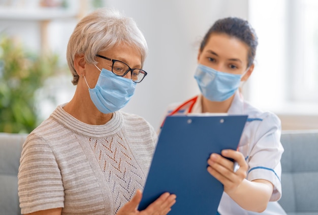 Doctor and senior woman wearing facemasks