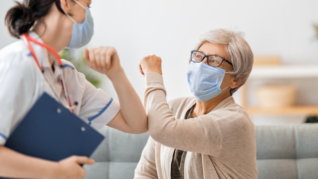 Doctor and senior woman wearing facemasks