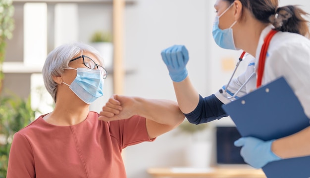 Doctor and senior woman wearing facemasks